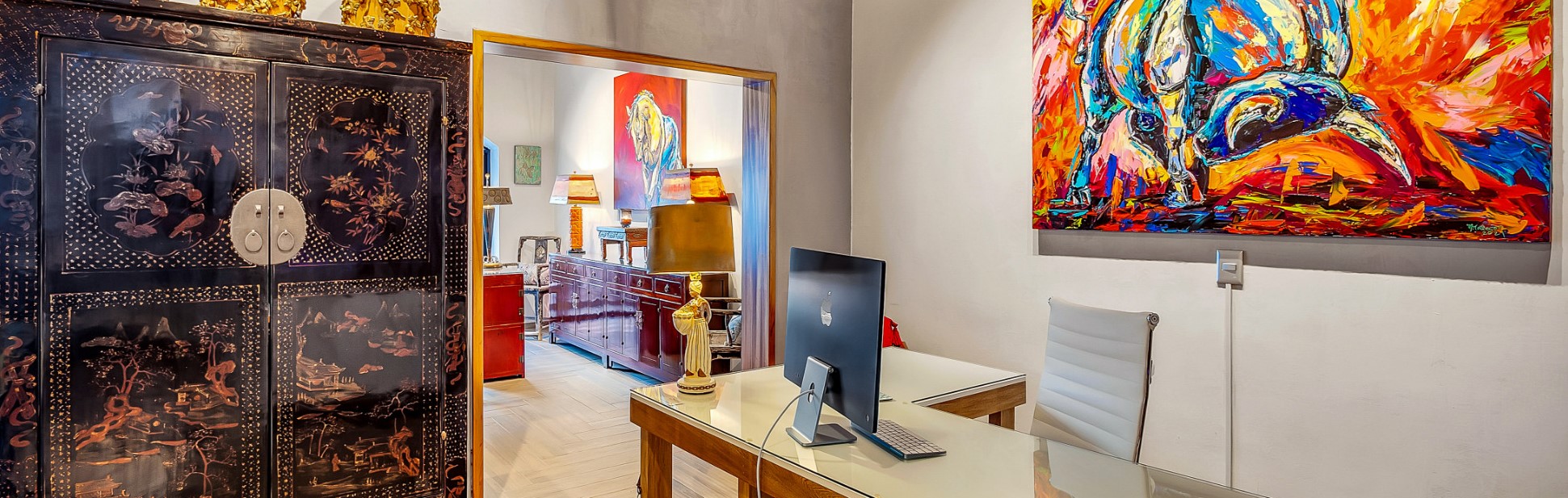 home office decorated with ornate furniture and colorful art on walls
