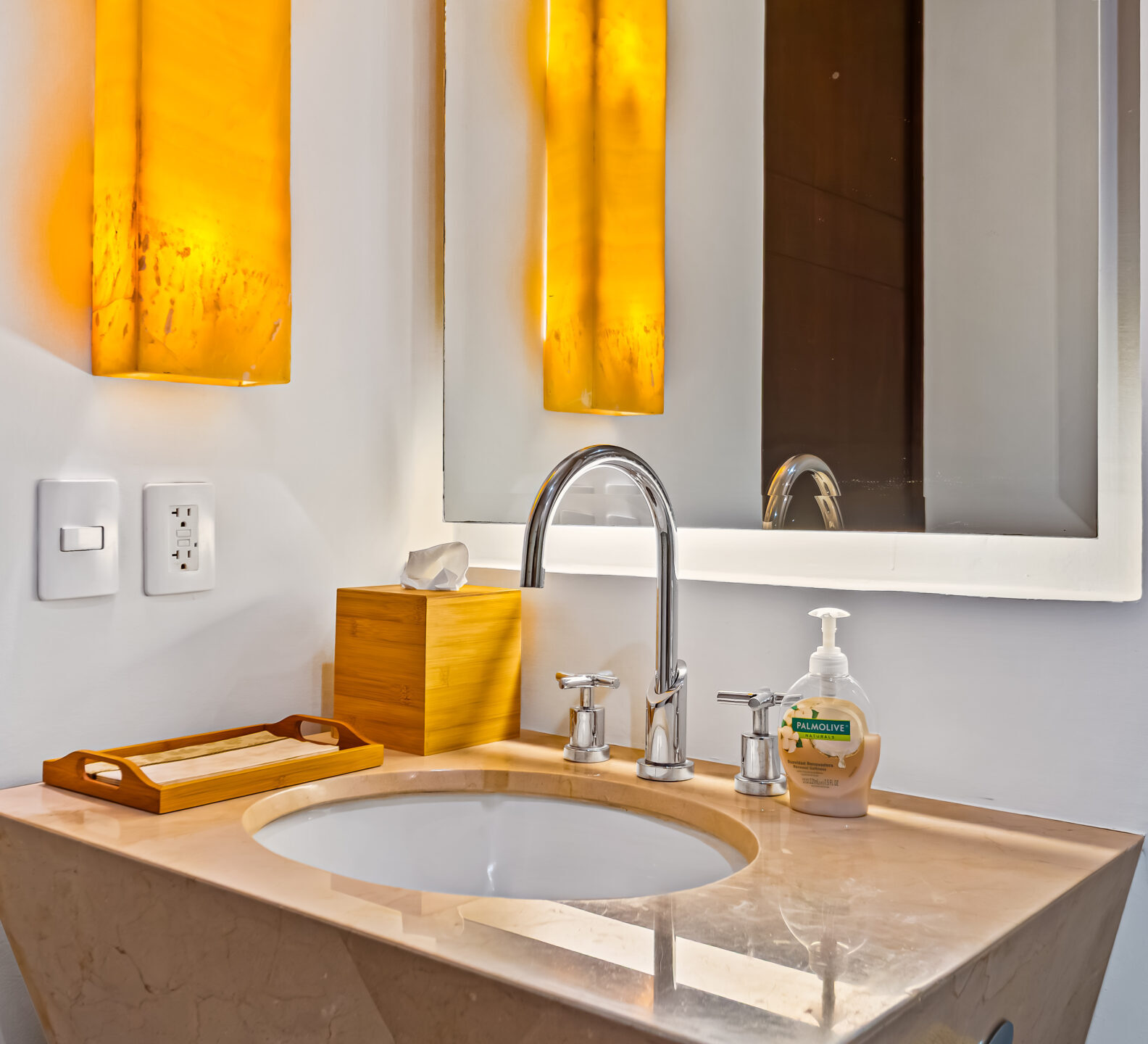 SDM Arco Major 4-1 Modern bathroom vanity with a stone countertop, vessel sink, illuminated wall sconces, and decorative accessories beneath a framed mirror.