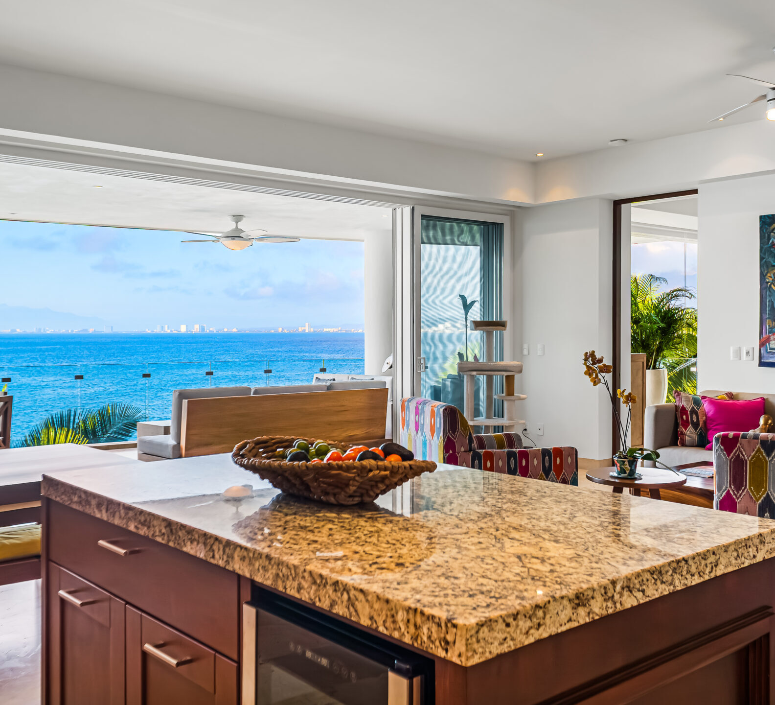 SDM Arco Major 4-13 Modern kitchen with granite countertops, wood cabinetry, bar seating, and a seamless connection to the oceanfront terrace.