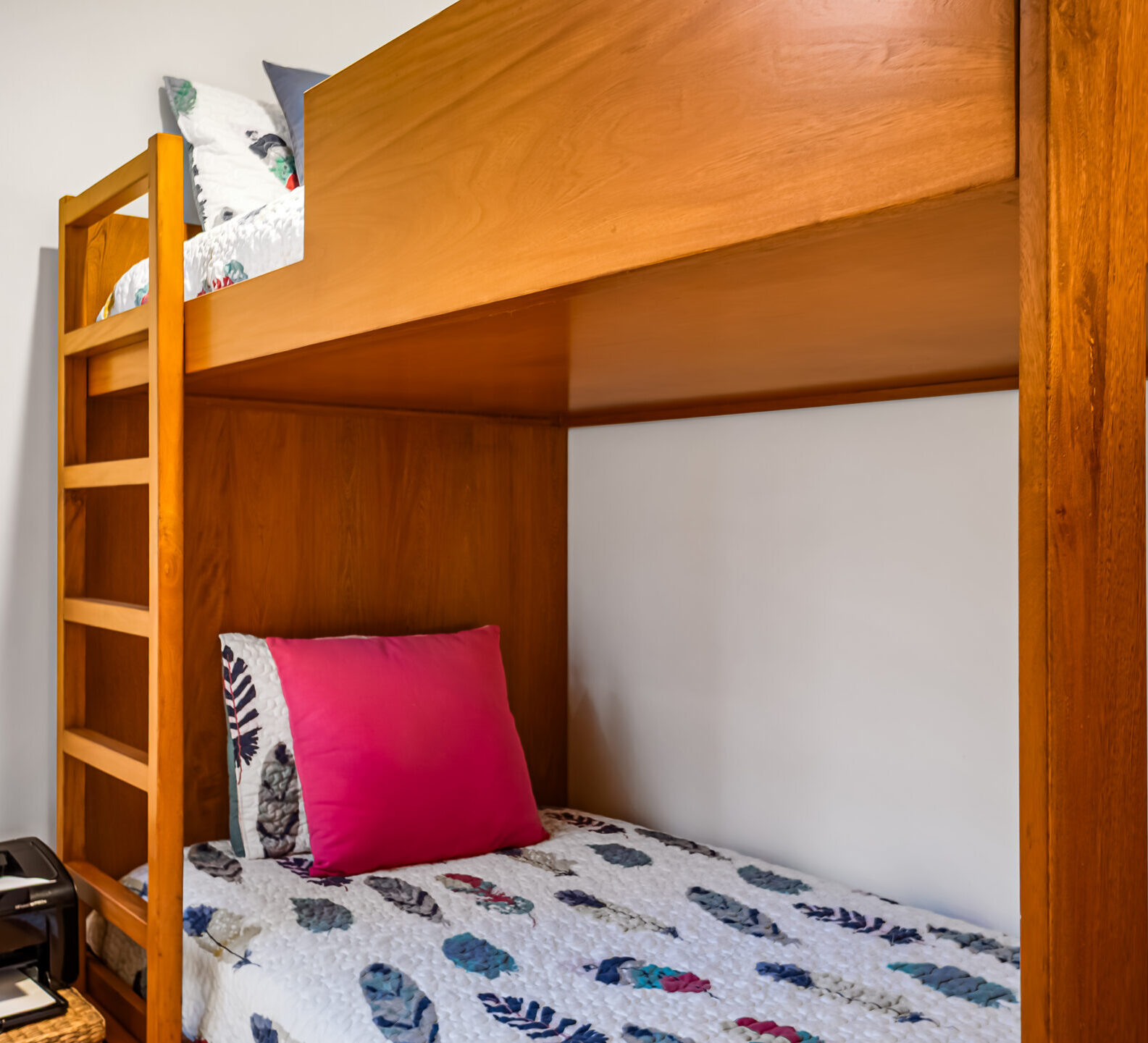 SDM Arco Major 4-2 Cozy bunk bedroom featuring a wooden bunk bed with ladder, patterned bedding, and colorful accent pillows in a bright, modern space.