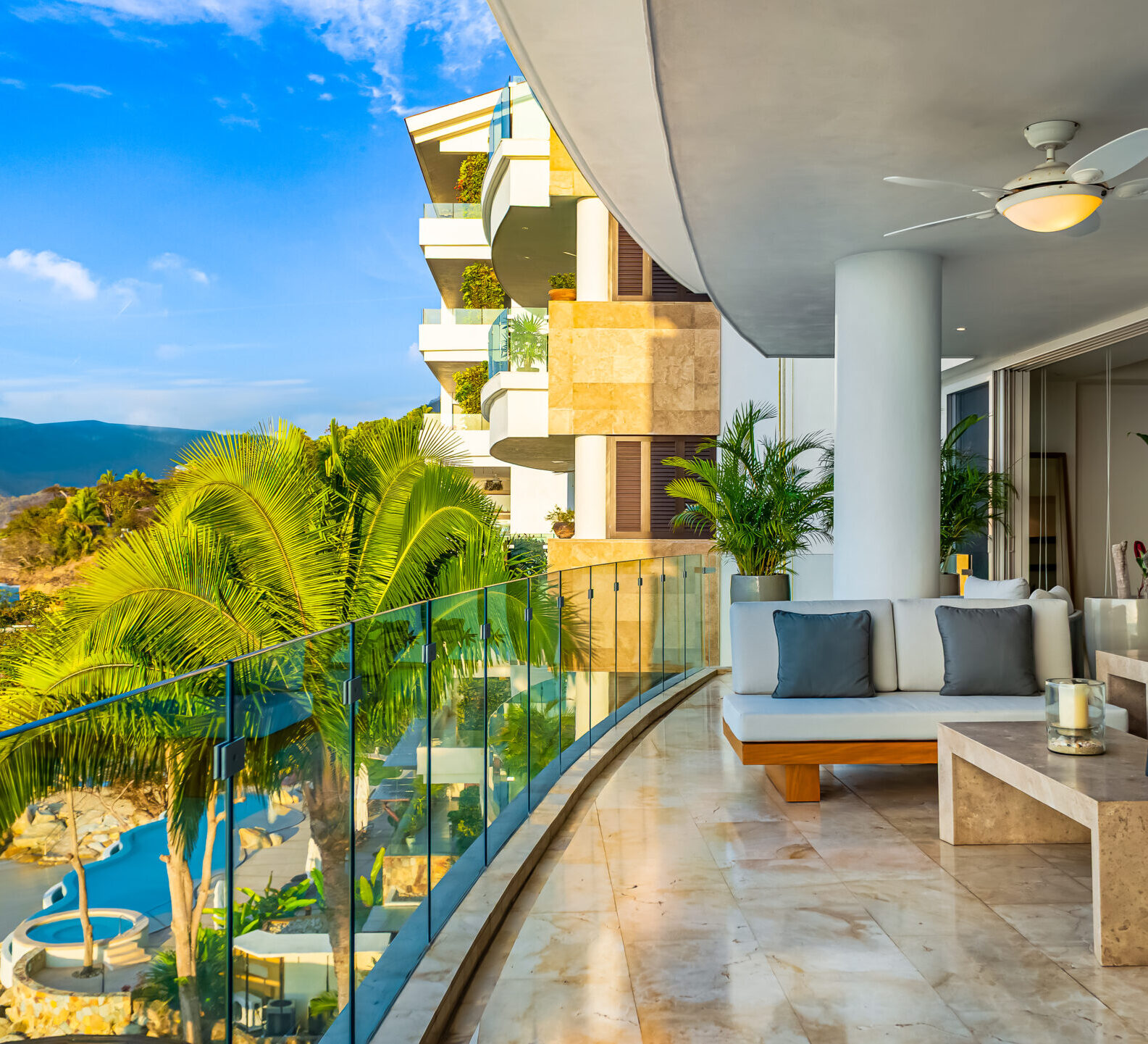 SDM Arco Major 4-38 Covered balcony with seating areas, palm trees, and expansive ocean views.