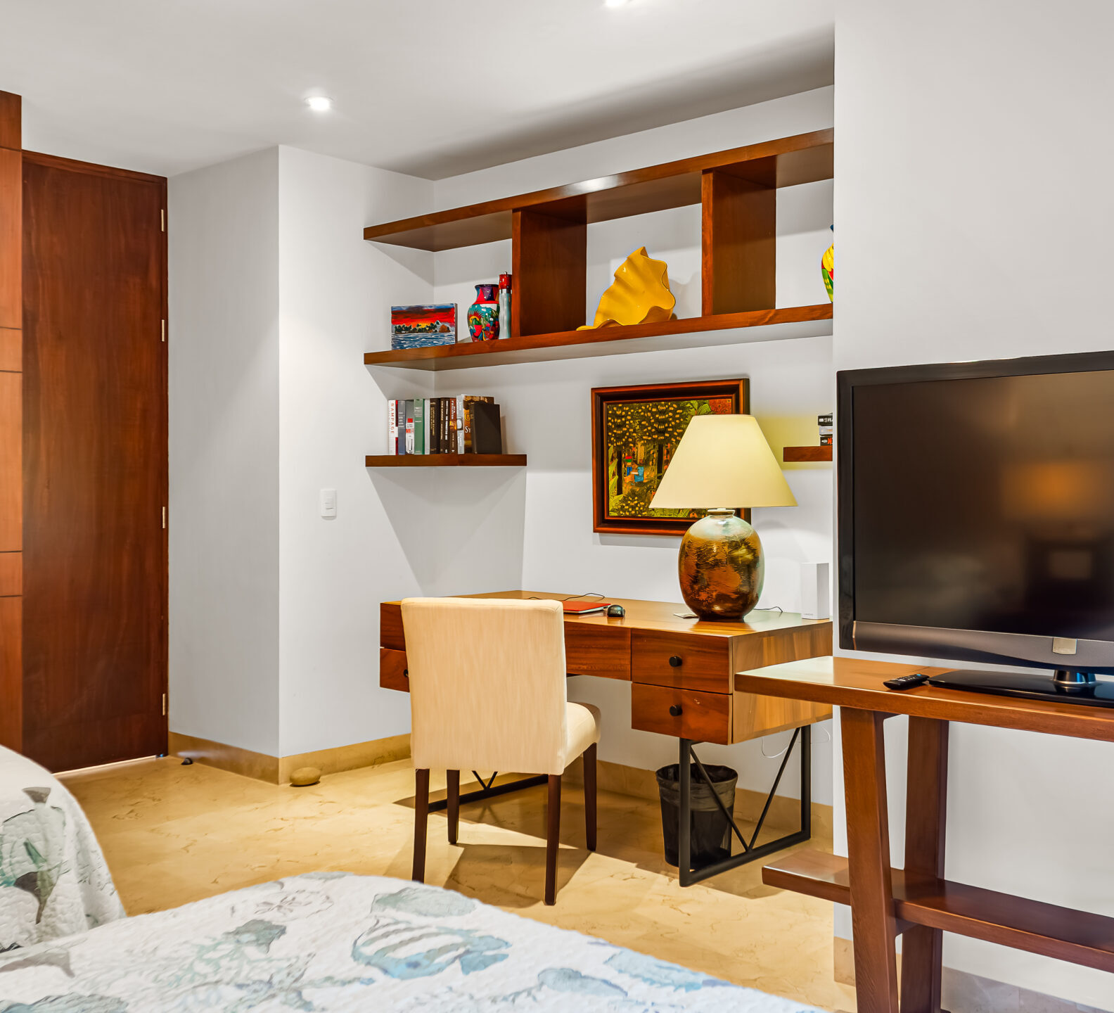 SDM Arco Major 4-50 Bedroom with a desk, built-in shelving, television, and wood louvered closet doors.