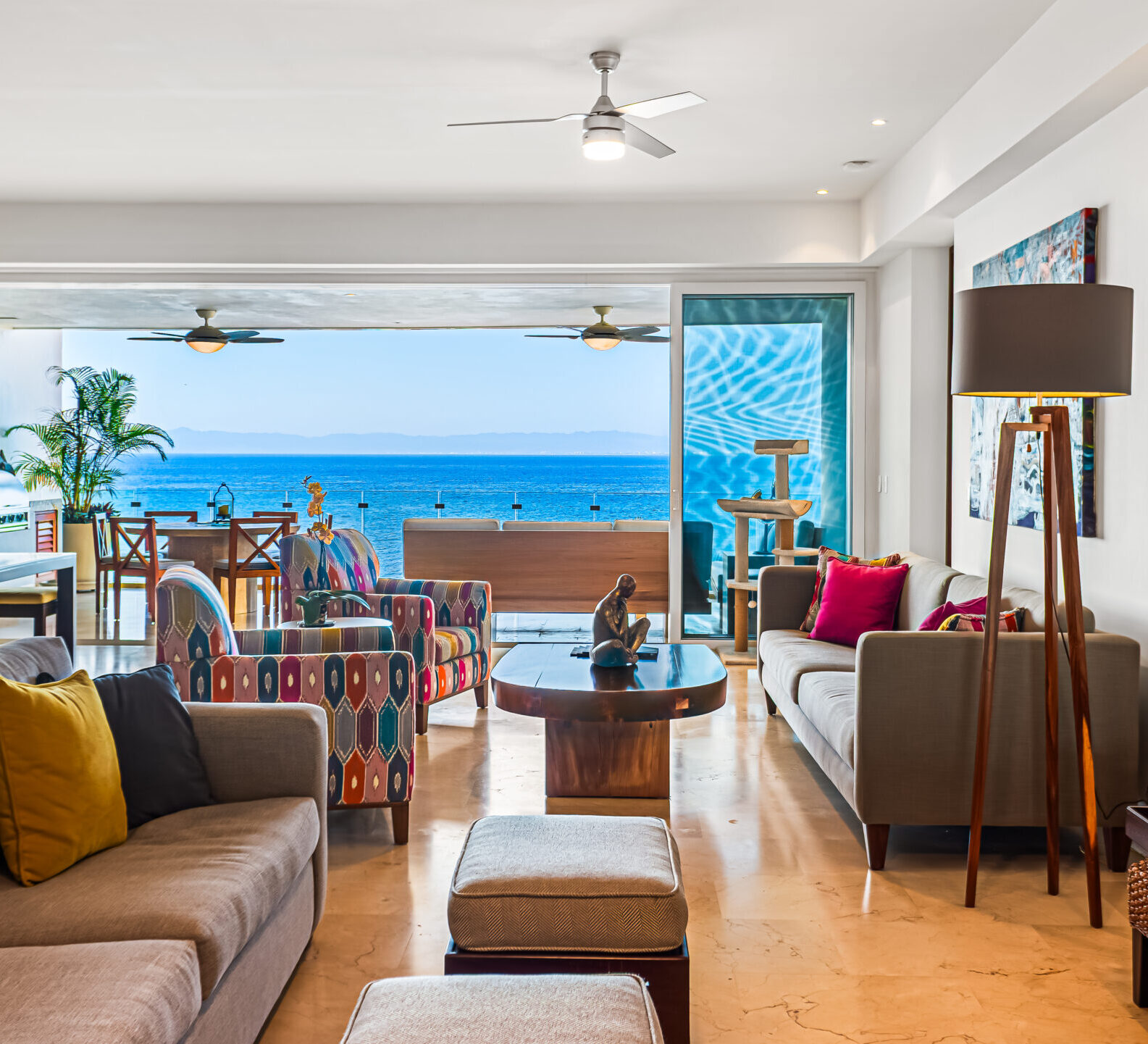 SDM Arco Major 4-6 Bright and airy living space featuring a sectional sofa, colorful furnishings, ceiling fans, and panoramic ocean views.