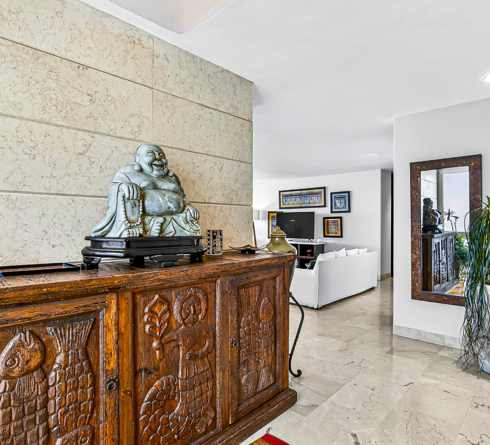 Interior entryway featuring a carved wood console table and decorative sculpture.