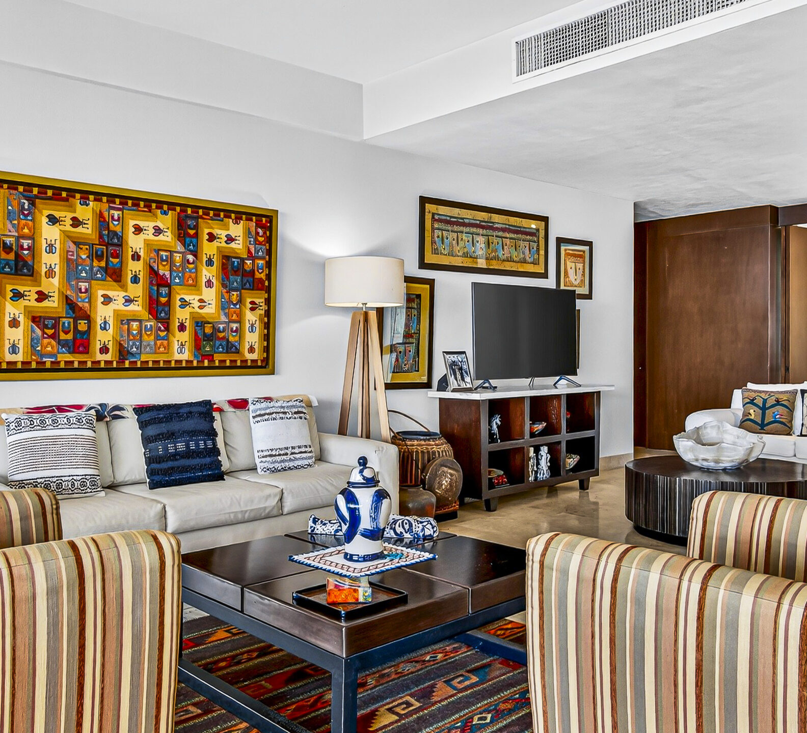 Living room with modern furnishings, decorative artwork, and comfortable seating.