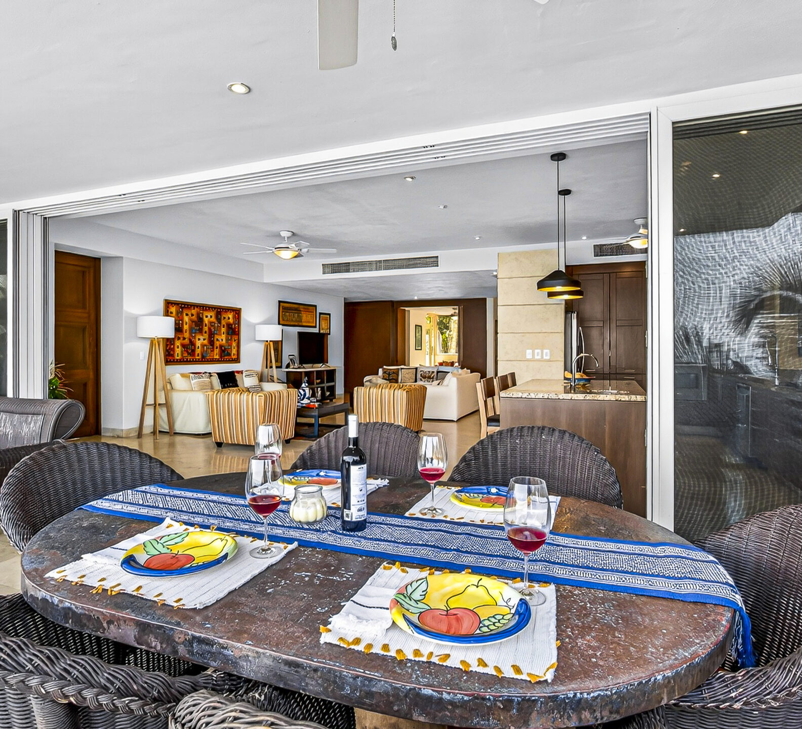 Outdoor dining area connected to an open-concept living room through sliding glass doors.