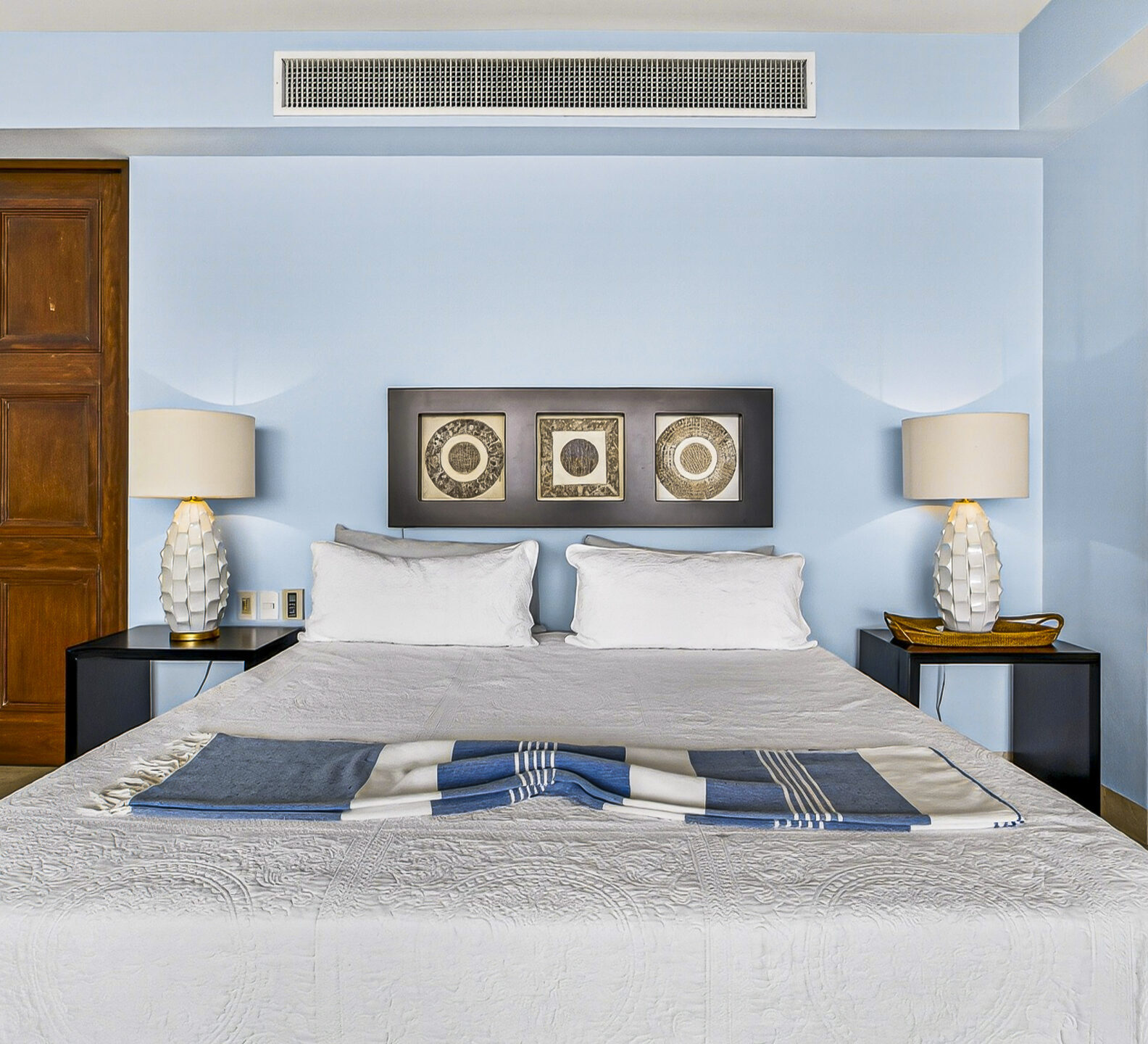 Bedroom with a king-size bed, matching nightstands, and contemporary furnishings.