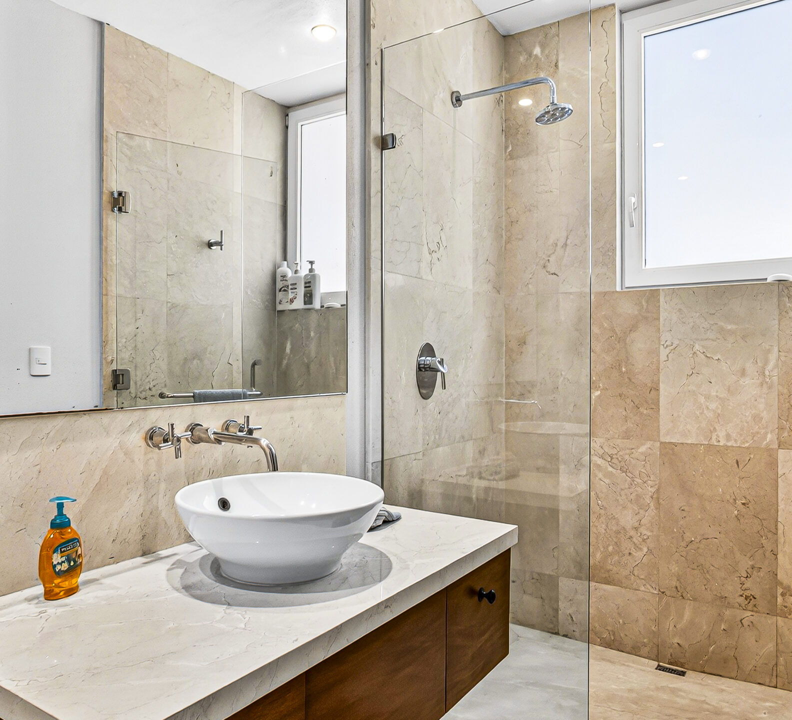 Bathroom with a vessel sink, stone finishes, and a glass-enclosed shower.