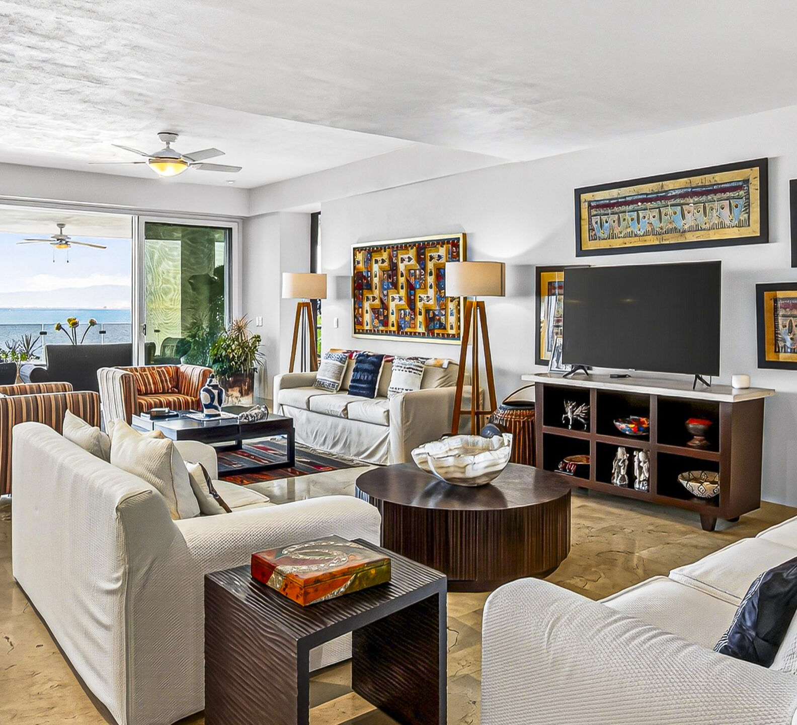 Spacious living room with comfortable seating and sliding doors opening to ocean views.