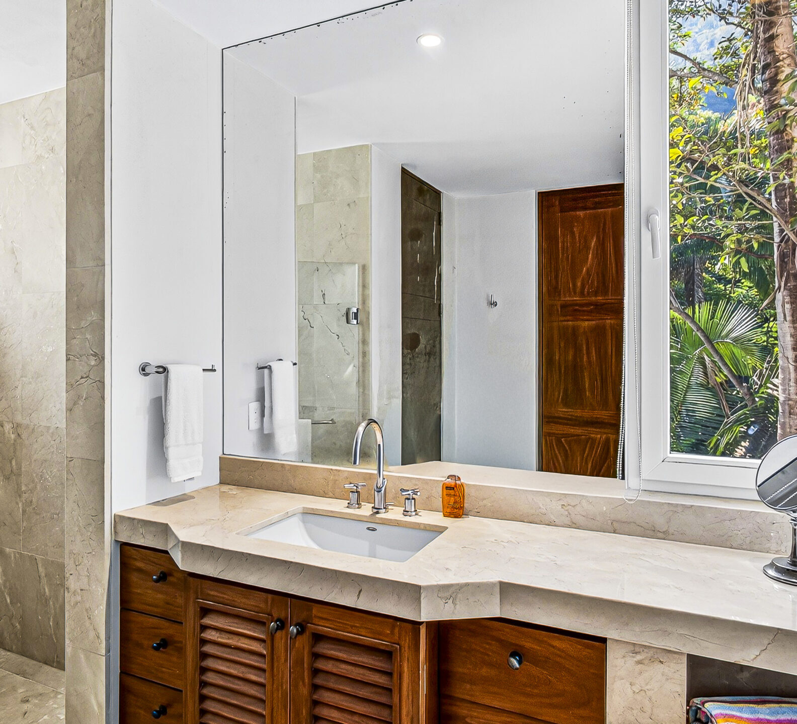Spacious bathroom with a double-sink vanity, large mirror, and natural light.