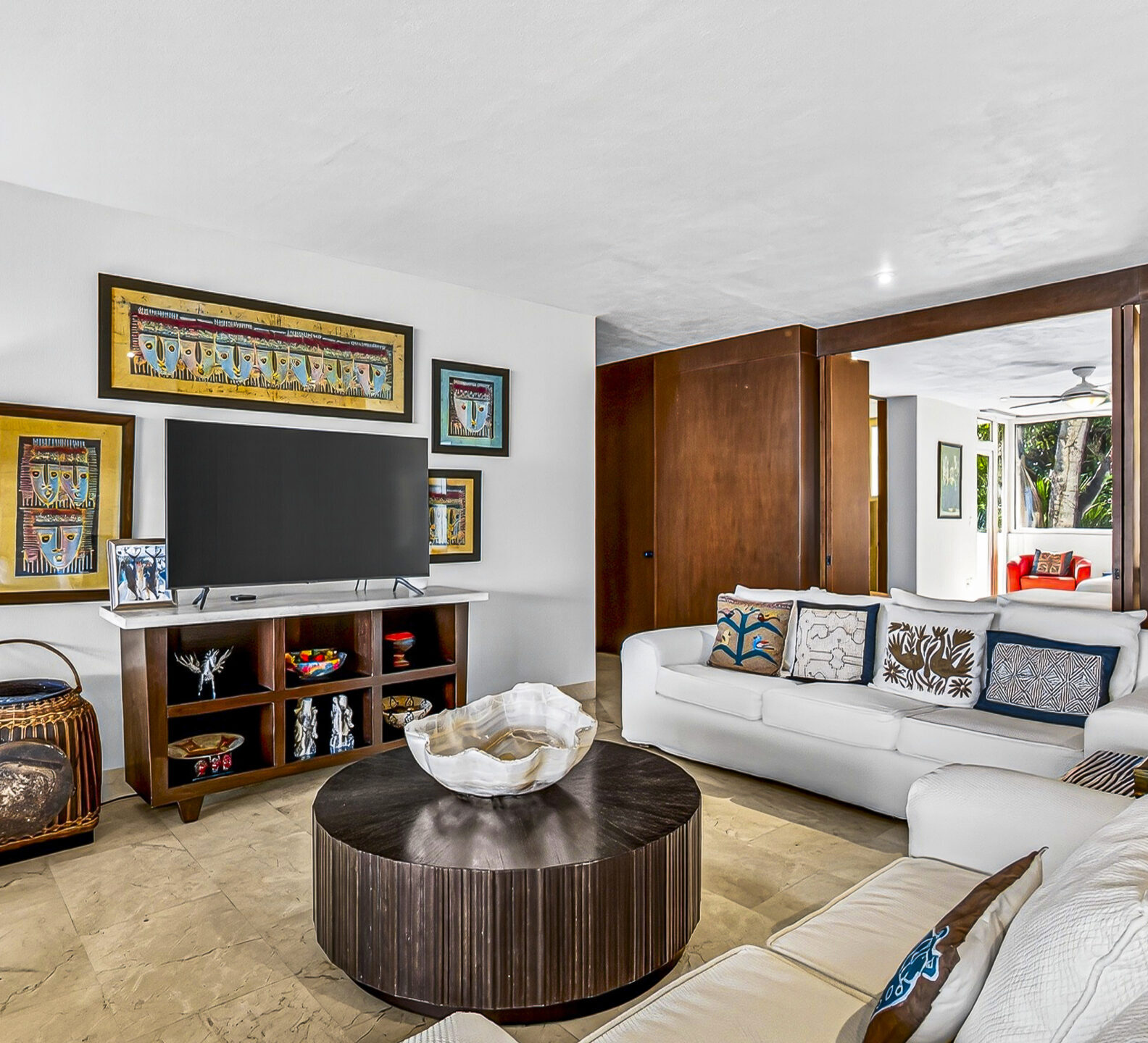 Comfortable living room with sectional seating, framed artwork, and a round coffee table.