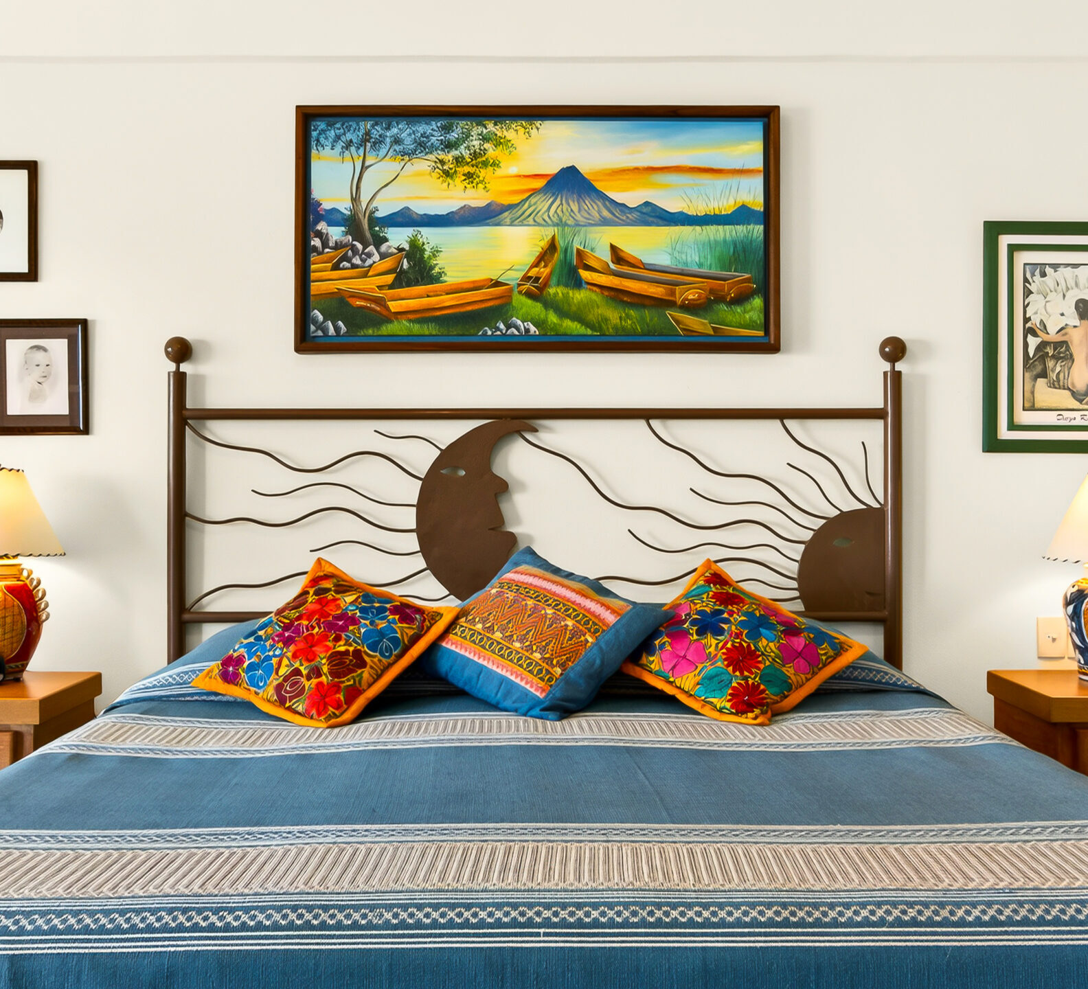 A king-sized bed with a decorative metal headboard and colorful throw pillows is centered between two wooden nightstands with lamps.