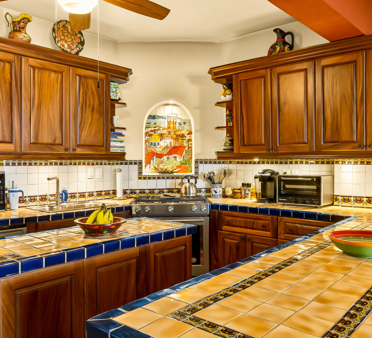 Traditional-style kitchen with extensive wood cabinetry, tiled work surfaces, modern appliances, and warm architectural details throughout.